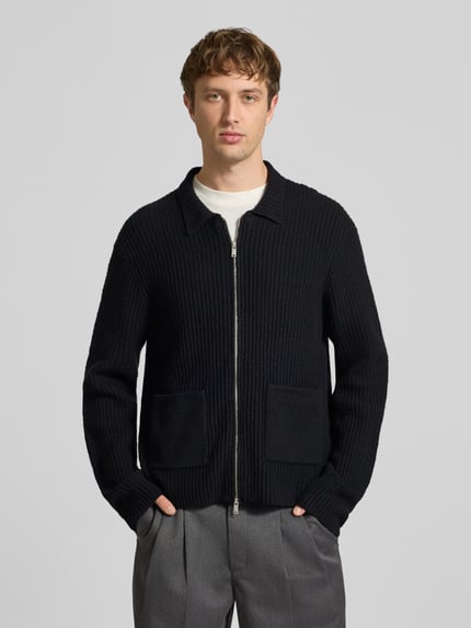 Männermodel trägt Strickjacke mit Zweiwege Reißverschluss von ONLY & SONS in unifarbener Strickoptik mit Struktur, Ganzkörperansicht von vorne.