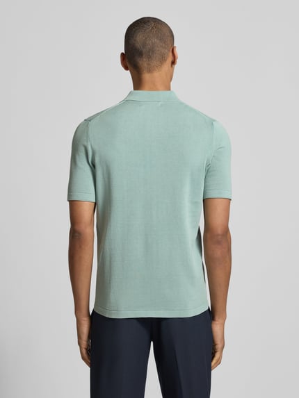 Männermodel trägt Regular Fit Poloshirt aus reiner Baumwolle von Marc O'Polo, efekt: jednolity kolor, krój regular fit, wyhaftowane logo, kołnierzyk polo, krótki rękaw, zakończenie rękawów zrolowany brzeg, wykończenie materiału: dzianina, materiał: bawełna, całkowity widok z tyłu
