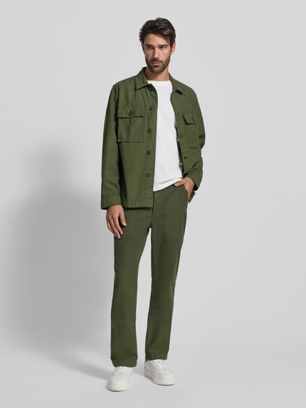 Männermodel trägt Regular Fit Chino aus reiner Baumwolle Modell 'MERCER' von Tommy Hilfiger, Optik: Unifarben, Ganzkörperansicht von vorne.