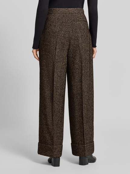 Frauenmodel trägt Weite Hose mit Woll-Anteil Modell 'Tianara' von BOSS in Braun meliert, lockere Passform, strukturierte Textur, Ganzkörperansicht Rückansicht, Damen Weite Hose von BOSS.