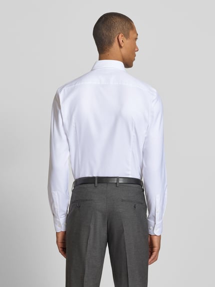 Männermodel trägt Slim Fit Businesshemd aus reiner Baumwolle Modell 'H-HANK-K' von BOSS in Weiß, Twill-Textur, Ganzkörperansicht Rückansicht.
