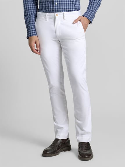 Mężczyzna nosi białą Stoffhose mit französischen Eingrifftaschen od Polo Ralph Lauren, Slim Fit, bawełna z elastanem, widok całej sylwetki z przodu.