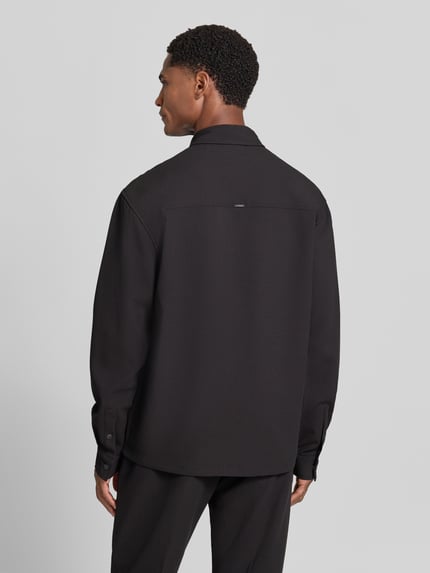 Männermodel trägt Regular Fit Hemdjacke mit Viskose-Anteil Modell 'SANTIAGO' von Antony Morato in Schwarz, Ganzkörperansicht Rückansicht. Material-Mix, Kentkragen, Druckknopfleiste, Brusttasche mit Druckknopf, Manschetten mit Druckknopf, Rückenlänge bei Größe 50: 65 cm.