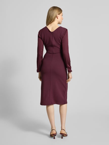 Frauenmodel trägt Cocktailkleid mit Raffungen von Rinascimento in dunklem Bordeaux, figurbetont, Material-Mix, Ganzkörperansicht Rückansicht