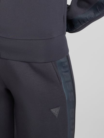 Frauenmodel trägt Sweatpants mit elastischem Bund Modell 'ALLIE' von Guess, dunkelgrau, Viskose-Mix, französische Eingrifftaschen, Nahaufnahme Oberkörper.