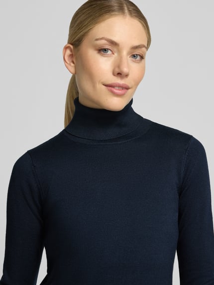 Frauenmodel trägt Slim Fit Strickpullover aus Viskose-Mix Modell 'IHLULS' von ICHI in Dunkelblau, feine Struktur, Nahaufnahme Oberkörper. Damen Strickpullover, Rollkragen, elastische Abschlüsse, Rückenlänge 61 cm, Ärmellänge 66 cm.