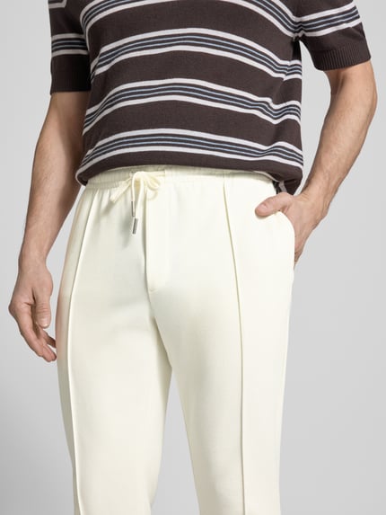 Männermodel trägt Regular Fit Hose mit elastischem Bund van Antony Morato in katoenmix met deelnaden, bandwijdte M 41 cm, binnenbeenlengte 76 cm, nahaufnahme bovenlichaam.