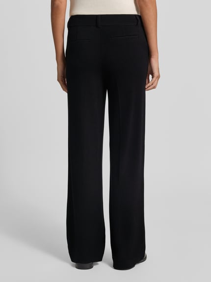 Frauenmodel trägt Fein strukturierte Hose aus Viskose von Christian Berg Woman, schwarze Farbe, strukturierte Oberfläche, Gesäßtaschen, Ganzkörperansicht Rückansicht. Regular Fit, Bundweite 40 cm, Innenbeinlänge 78 cm.