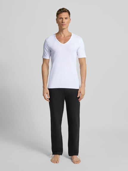 Męski model nosi T-shirt mit V-Ausschnitt von MCNEAL, mieszanka bawełny, krój regular fit, dekolt w serek, szwy działowe, widok z przodu.