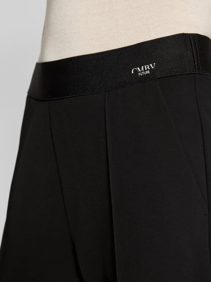 Vrouwenmodel draagt Straight Fit Stoffhose met Ziernaht Modell 'Cameron' van Cambio, elastische tailleband, logo-print, detailopname taille