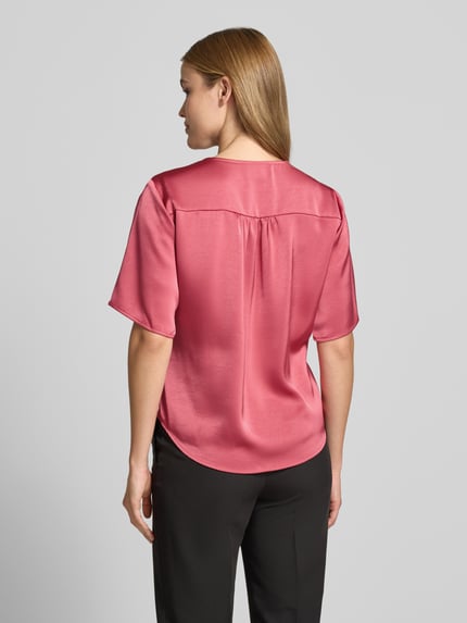 Frauenmodel trägt Bluse mit Knoten-Detail Modell 'Casadia' von Neo Noir aus Satin in Rosa, Straight Fit, Rückenlänge 61 cm, Ganzkörperansicht Rückansicht.