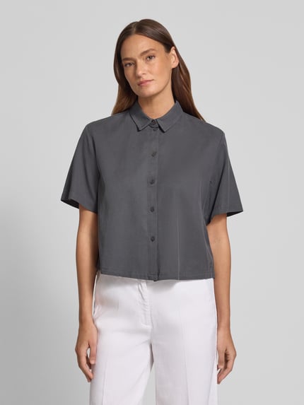 Vrouwenmodel draagt Boxy Fit Bluse aus Lyocell-Baumwoll-Mix van Jake*s Casual in grijs met overhemdkraag en knoopsluiting, voorkant bovenlichaam. Ruglengte maat 36: 55 cm, mouwlengte maat 36: 25 cm.
