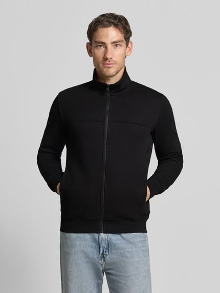 Männermodel trägt Regular Fit Sweatjacke aus Baumwoll-Mix von s.Oliver RED LABEL in Schwarz, glatte Struktur, Ganzkörperansicht von vorne.