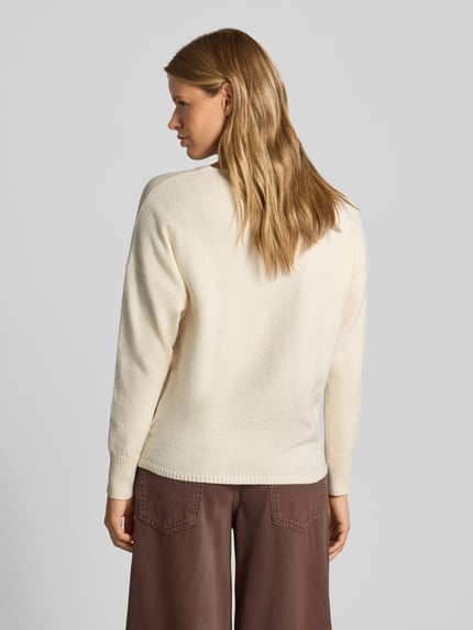 Modelka nosi Relaxed Fit Pullover mit V-Ausschnitt od ONLY, sweter kremowy, gładka faktura, widok całej sylwetki z tyłu