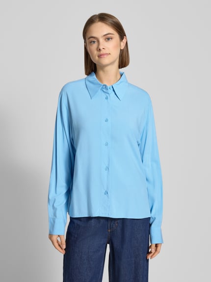 Vrouwenmodel draagt Regular Fit Hemdbluse uit pure viscose van Marc O'Polo Denim, effen lichtblauw, lange mouwen, voorkant volledige lichaamsweergave.