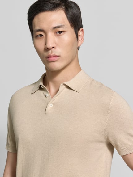 Männermodel trägt Regular Fit Poloshirt aus reiner Baumwolle Modell 'BERG' von SELECTED HOMME, unifarben, Feinripp, Nahaufnahme Oberkörper.