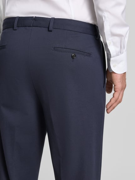 Männermodel trägt Regular Fit Anzughose mit Bügelfalten Modell 'Rennet' von JOOP!, dunkelblau, feine Textur, Detailaufnahme Rückansicht, Material-Mix mit Viskose-Anteil, Gesäßtaschen.