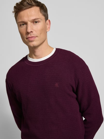 Männermodel trägt Strickpullover mit gerippten Abschlüssen von CK Calvin Klein aus Baumwoll-Mix mit Stretch-Anteil, Regular-Fit, Nahaufnahme Oberkörper.