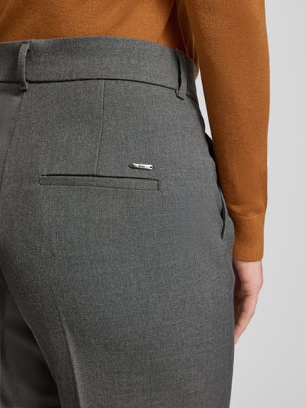 Vrouwenmodel draagt Straight Fit Stoffhose mit Viskose-Anteil Modell 'Maine' van Brax, grijze stof, detailopname heup, elastisch materiaal, persvouwen.