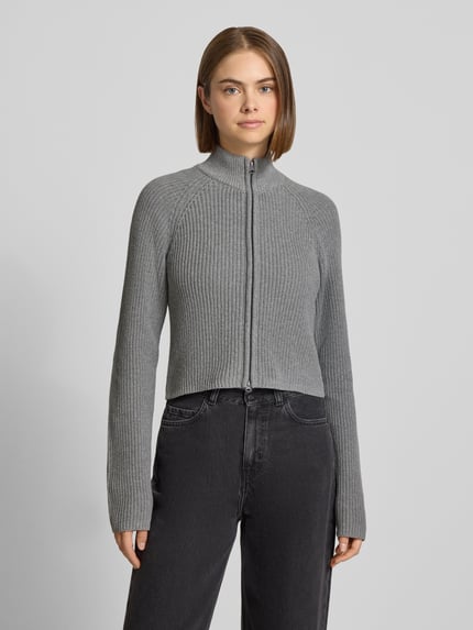 Frauenmodel trägt Slim Fit Jacke aus Baumwoll-Mix Modell 'Dara' von NOISY MAY®, grau, strukturierte Rippenoptik, Zweiwege-Reißverschluss, Stehkragen, Ganzkörperansicht von vorne.