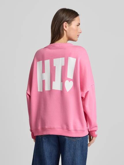 Frauenmodel trägt Sweatshirt mit Label-Detail von miss goodlife in Pink, lockerer Schnitt aus Baumwolle, gerippte Abschlüsse, Ganzkörperansicht Rückansicht.