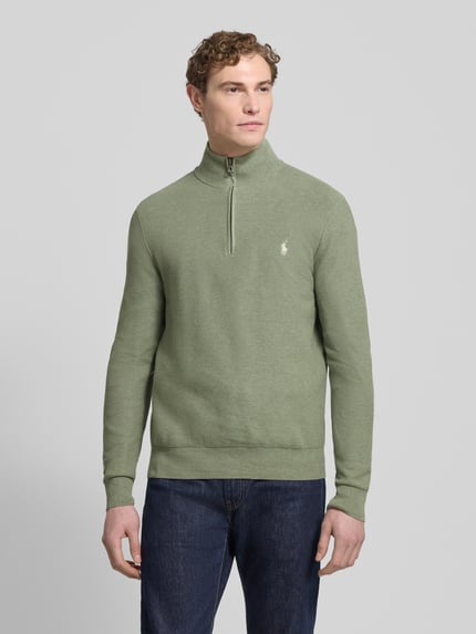 Männermodel trägt Strickpullover mit Label-Stitching von Polo Ralph Lauren in Grün, Reine Baumwolle, Regular-Fit, Stehkragen, Gerippte Abschlüsse, kurzer Reißverschluss, Ganzkörperansicht von vorne.