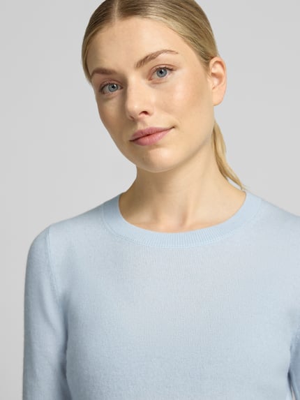 Frauenmodel trägt Slim Fit Strickpullover aus reinem Kaschmir von Christian Berg Woman in Hellblau, weiche Textur, Nahaufnahme Oberkörper.