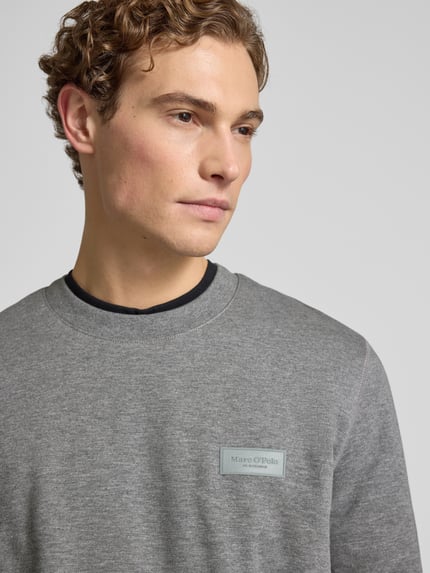Männermodel trägt Regular Fit Sweatshirt aus reiner Baumwolle von Marc O'Polo, Optik: Unifarben, Label-Patch, Nahaufnahme Oberkörper.