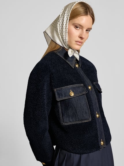 Kobiece modelka nosi Bouclè-Jacke mit Kentkragen und Brusttaschen od LUISA CERANO, kolor granatowy, złote guziki, prosty krój, tekstura bouclé, naszywane kieszenie na piersi, kołnierzyk typu kent, zapięcie na guzik, długość tyłu w rozmiarze 36: 58 cm, szerokość ramion: 42 cm, szerokość klatki piersiowej: 52 cm, długość rękawów: 57 cm, całkowity widok z przodu.
