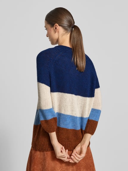 Frauenmodel trägt Relaxed Fit Pullover mit Woll-Anteil in Strick-Optik von MORE & MORE, Blockstreifen in Blau, Beige und Braun, Ganzkörperansicht Rückansicht.