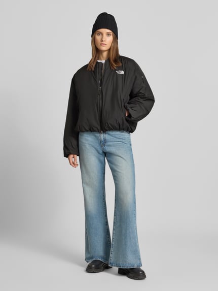 Frauenmodel trägt Bomberjacke mit Label-Stitching Modell 'CHOQA' von The North Face, schwarz, Relaxed Fit, Ganzkörperansicht von vorne.