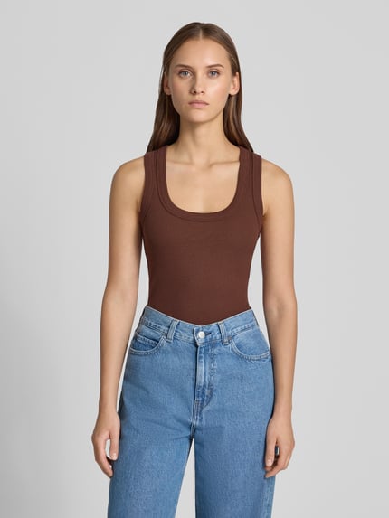 Modelka kobieca nosi Tanktop in Ripp-Optik Modell 'HONEY' od Topshop, brązowy, bawełna z elastanem, krój slim fit, okrągły dekolt, faktura prążkowana, długość pleców w rozmiarze S: 53 cm, zdjęcie całej sylwetki z przodu.