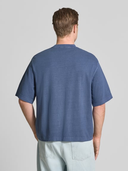 Männermodel trägt Boxy Fit T-Shirt aus reiner Baumwolle Modell 'CORY' von Selected Homme in Blau, lockere Passform, Ganzkörperansicht Rückansicht, Herren T-Shirt von Selected Homme.