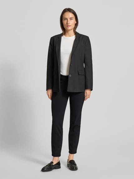 Modelka kobieca nosi Hose mit Paspeltaschen am Gesäß Modell 'RENIRA' von Cambio, czarne spodnie z domieszką stretchu, widok całej sylwetki z przodu.