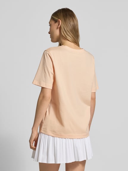 Frauenmodel trägt Relaxed Fit T-Shirt aus reiner Baumwolle von Lacoste in Unifarben mit Logo-Stitching, Rückansicht Ganzkörperansicht.
