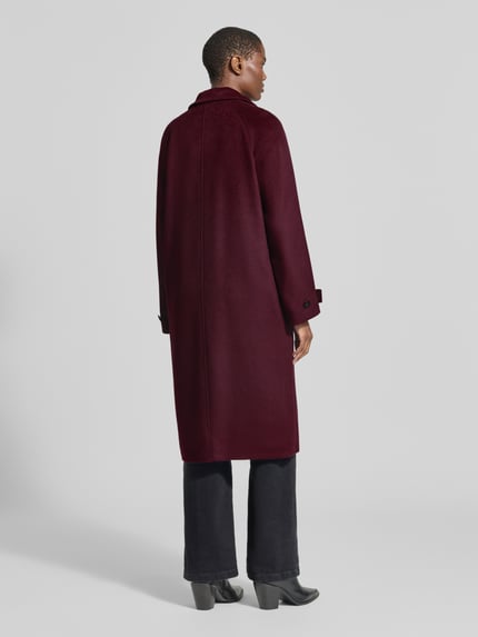 Frauenmodel trägt Regular Fit Mantel mit Stehkragen von Christian Berg Woman Selection in Dunkelrot, glatte Oberfläche, Eingrifftaschen, Knopfverschluss, Ganzkörperansicht Rückansicht. Rückenlänge 111 cm, Schulterbreite 38 cm, Brustweite 35 cm, Ärmellänge 46 cm.