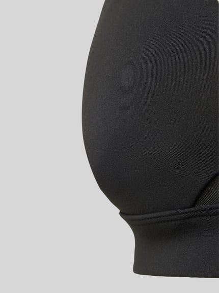 Frauenmodel trägt Sport BH mit semitransparenten Partien Modell 'Pureluxe' von Fabletics, elastischer Material-Mix, Detailaufnahme.