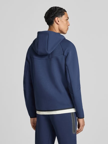 Mannelijk model draagt Regular Fit Sweatjacke aus Baumwoll-Mix van Nike in effen donkerblauw met glad oppervlak, Ganzkörperansicht Rückansicht.