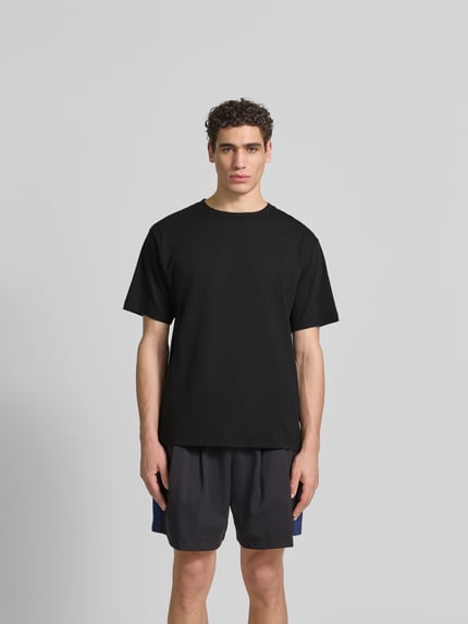 Mannmodel draagt T-shirt met ronde hals van Kenzo, puur katoen, relaxed fit, gestikt logo, met korte mouwen, ruglengte maat M 68 cm, zwart, rechte lijnen, zachte textuur, effen kleur, Ganzkörperansicht van voren.