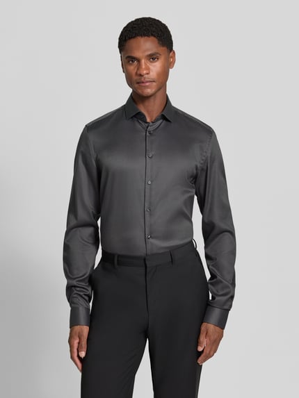 Männermodel trägt Slim Fit Businesshemd in Premiumqualität mit extra langem Arm von Jake*s, dunkles Big Twill-Baumwollgewebe, Ganzkörperansicht von vorne.
