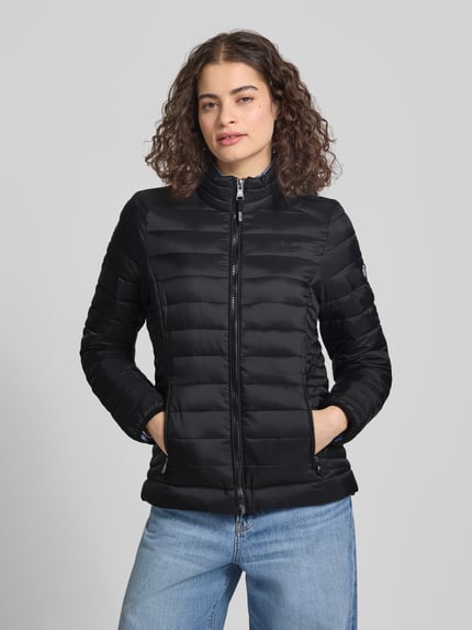 Vrouwenmodel draagt Steppjacke mit Logo-Stitching Modell 'FUJI' van Superdry in zwart, gerader fit, ritssluiting, ritszakken, opstaande kraag, vooraanzicht bovenlichaam.