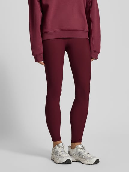 Frauenmodel trägt Leggings mit elastischem Bund Modell 'Cherry Ribbed Performance' von AIMN, Bordeauxrot, gerippte Textur, Nahaufnahme Unterkörper.