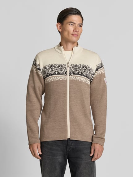 Männermodel trägt Regular Fit Jacke aus reiner Wolle Modell 'Moritz' von Dale of Norway in Strick-Optik, beige-schwarz, Ganzkörperansicht von vorne.