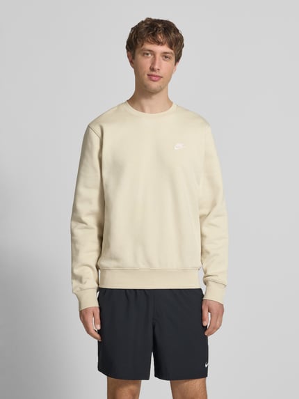 Männermodel trägt Sweatshirt mit Label-Stitching und Rundhalsausschnitt von Nike in Beige, Baumwoll-Mix, Regular-Fit, Ganzkörperansicht von vorne. Rückenlänge bei Größe M: 69 cm, Ärmellänge bei Größe M: 71 cm.