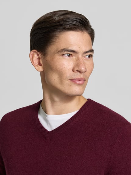 Mannenmodel draagt gebreide pullover van kasjmier met v-hals van Christian Berg Men in bordeaux, regular fit, Nahaufnahme Oberkörper. Ruglengte bij maat M: 71 cm, mouwlengte bij maat M: 71 cm.