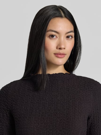 Vrouwenmodel draagt Regular fit shirt met lange mouwen van katoenmix model 'ZIA' van VERO MODA in zwart, detailopname bovenlichaam.