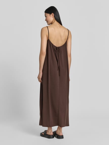 Frauenmodel trägt Midikleid aus Modal-Mix mit Spaghettiträgern von Jake*s Casual in Braun, lockere A-Linie, Ganzkörperansicht Rückansicht. Rückenlänge bei Größe S: 100 cm, Brustweite bei Größe S: 38 cm, fließender Stoff.