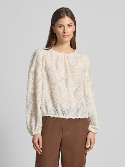 Frauenmodel trägt Regular Fit Bluse mit Fransen und Rundhalsausschnitt von Oui, helle Farbe, Struktur, mit Tunnelzug, Ganzkörperansicht von vorne. Rückenlänge bei Größe 36: 51 cm, Ärmellänge bei Größe 36: 63 cm.