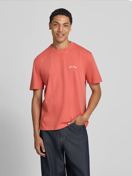Männermodel trägt leuchtend orangerotes Regular Fit T-Shirt aus reiner Baumwolle Modell 'John Tee' von Pepe Jeans, Herren T-Shirt, Ganzkörperansicht von vorne.