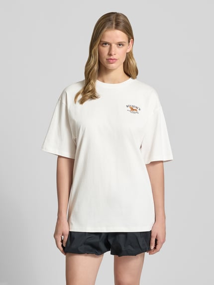 Frauenmodel trägt T-Shirt mit 1/2-Arm von REVIEW, Damen T-Shirt aus Reine Baumwolle, Lockerer-Schnitt, Rundhalsausschnitt, Rückenlänge 68 cm, Ganzkörperansicht von vorne.